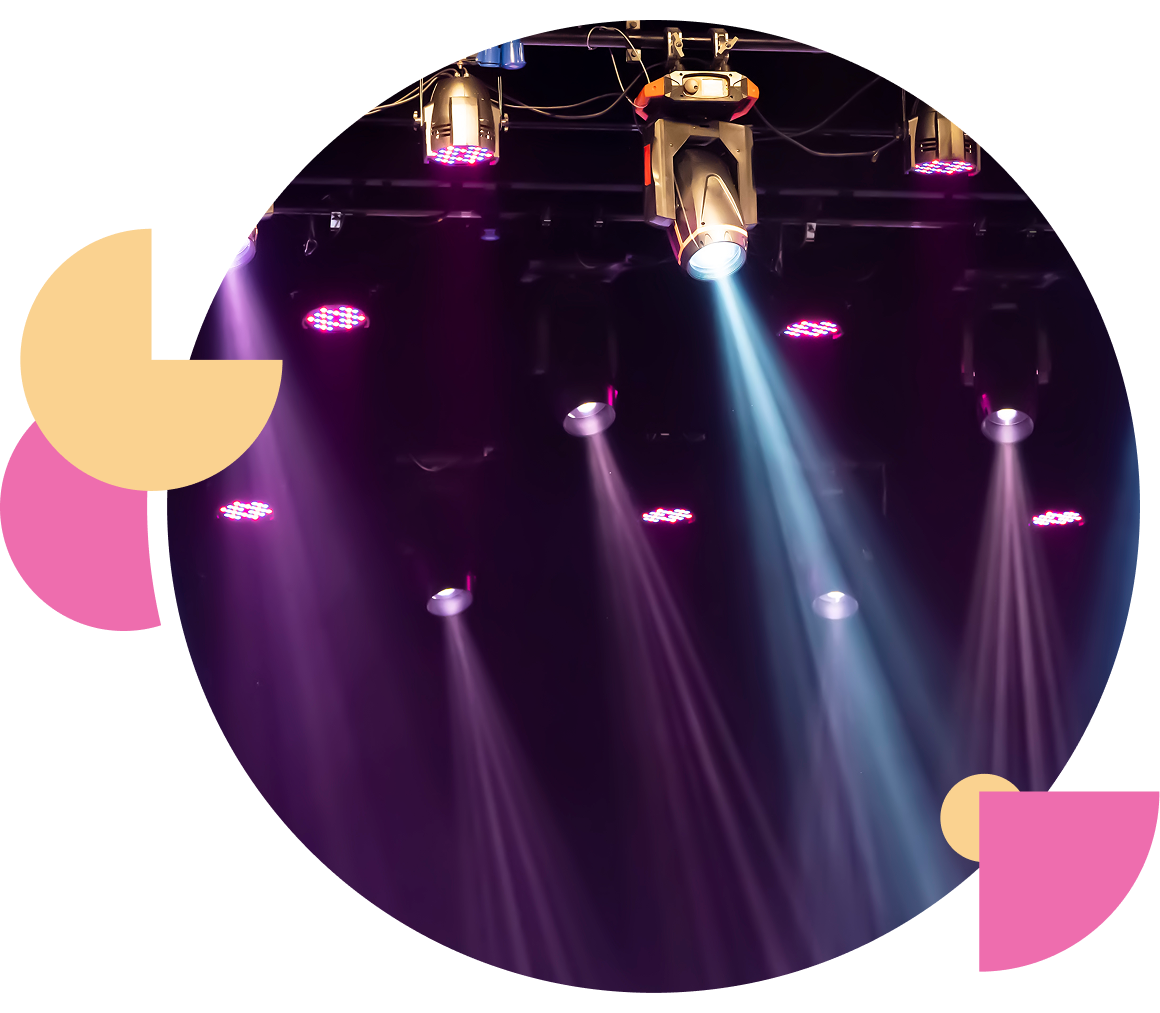 Purple stage lights shining down in a dark venue.